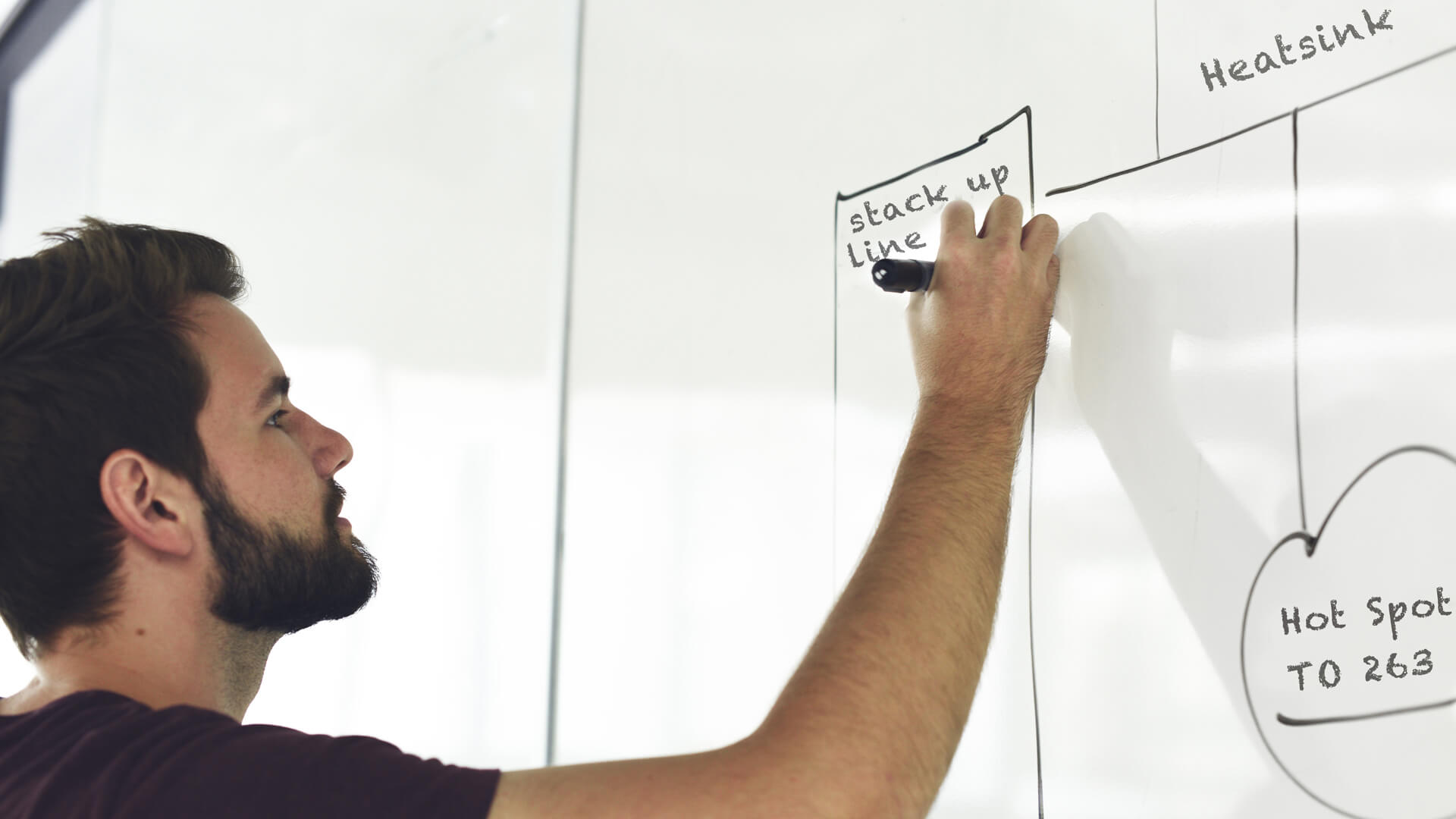 Mann schreibt auf Whiteboard